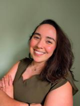 A woman with black hair wearing a green shirt