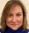 A woman with blonde hair wearing a blue shirt 