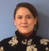 A woman with brown hair wearing a black and white sweater