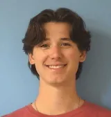 A man wearing a red shirt with a blue background