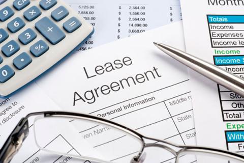 Lease agreement with pen, calculator and glasses
