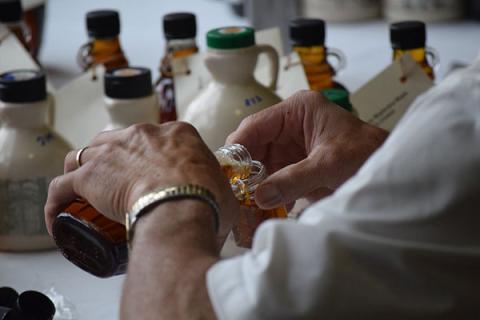 Person pouring maple syrup into a jar