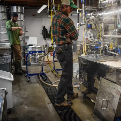 Two people in a maple production facility