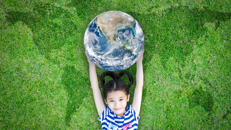 kid raising world on green lawn