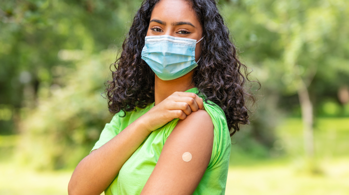 woman showing arm with bandaid from flu vaccine