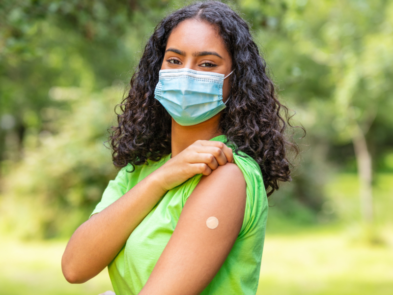 woman showing arm with bandaid from flu vaccine