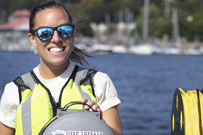 Ashley runs equipment on boat on lake