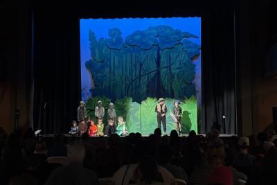 Students performing a play with hunters and animals