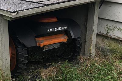 Mo, the robotic lawnmower, in his doghouse