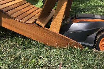 Mo, the robotic lawnmower, dug in behind Adirondack chair