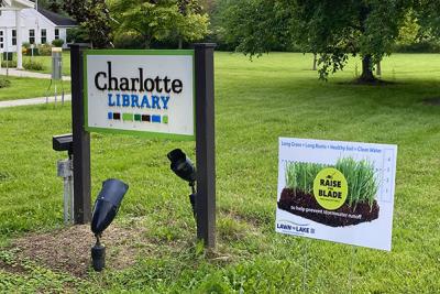 Charlotte Library sign, lawn and Raise the Blade sign