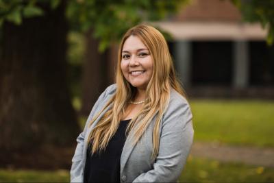 Portrait of Rosie Chapina standing outside in front of trees