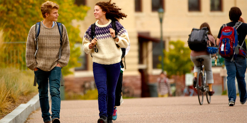 Two students walk along a path chatting