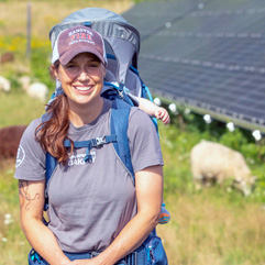 Amber Reed sitting in a field with cows