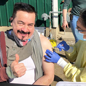Alejandro getting vaccinated and giving a thumbs up