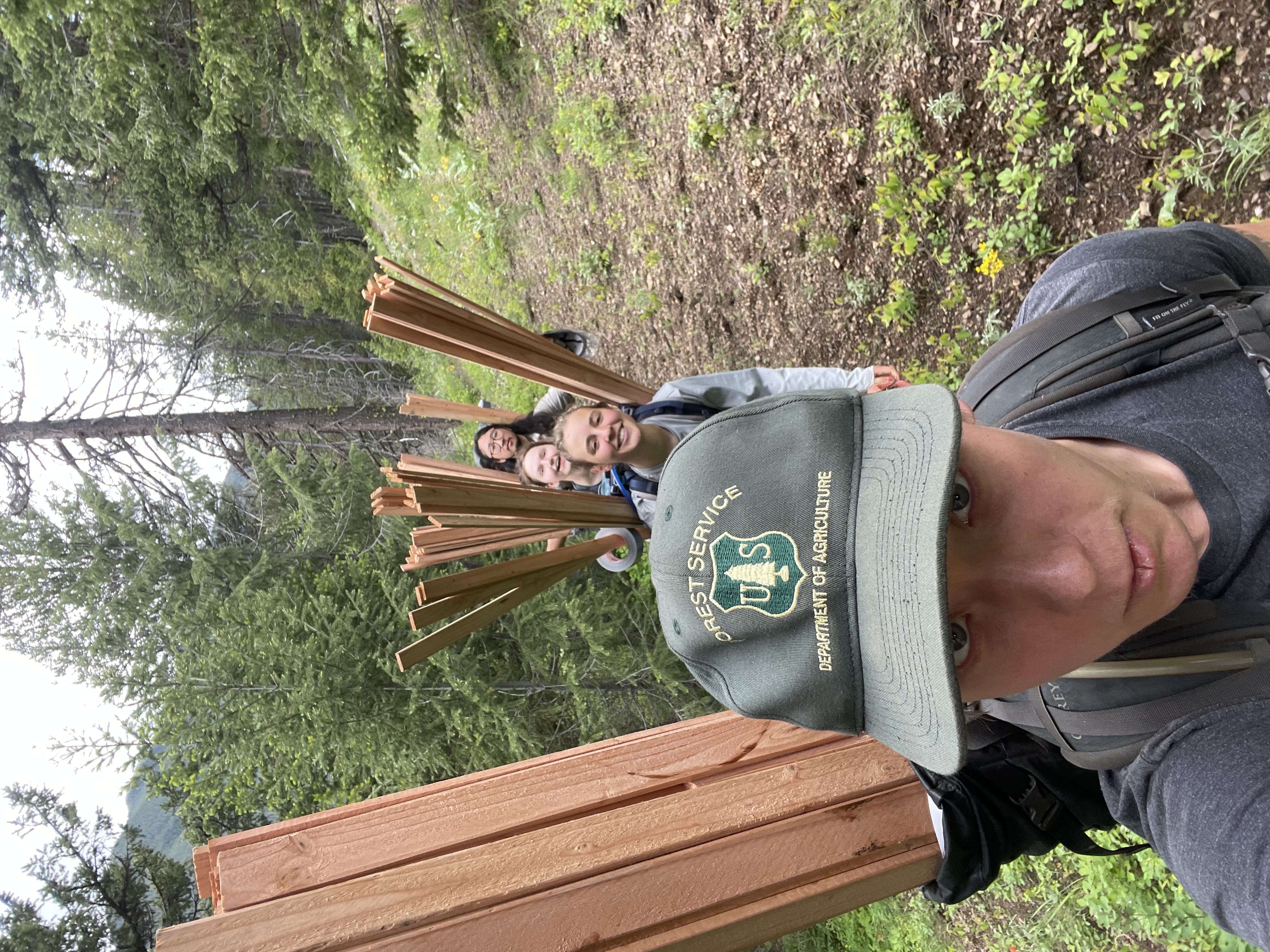 Grant with service crew members in the woods.