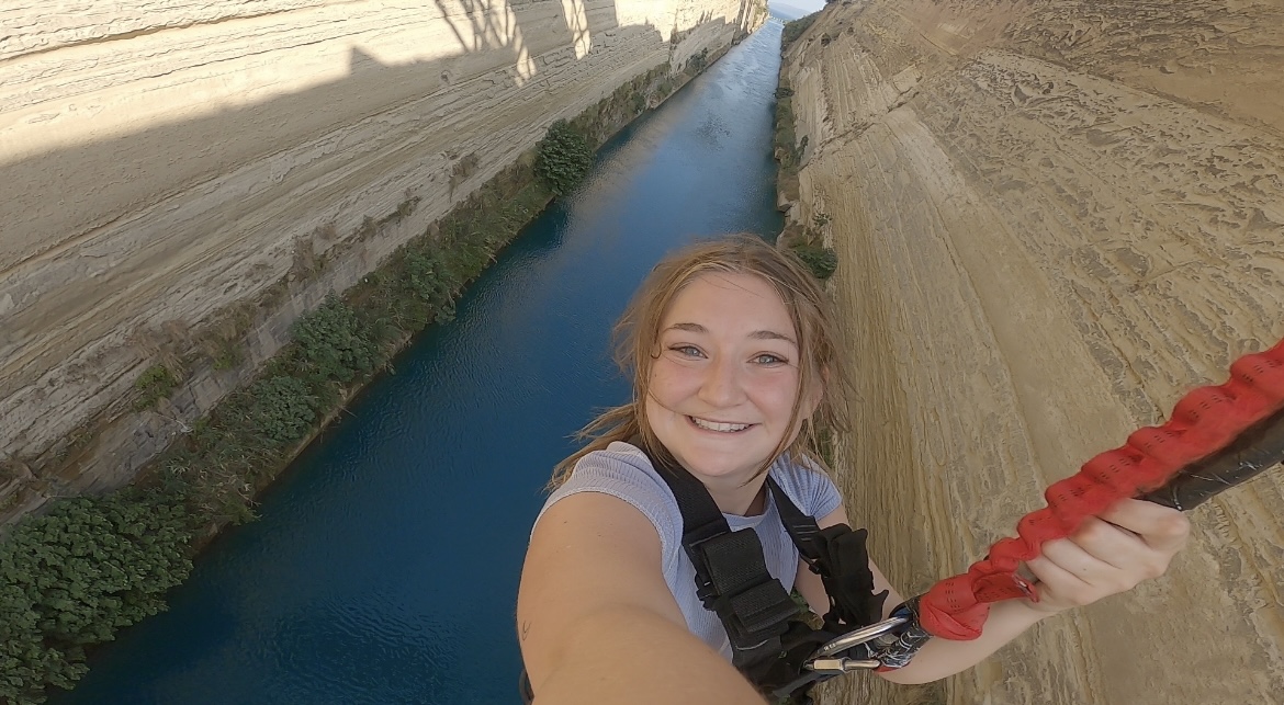 Caroline hanging over a river while bungee jumping.