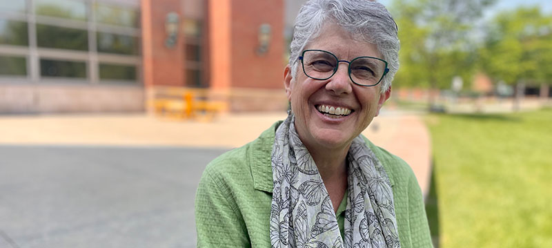 Sharon is outside the Davis Center on a sunny day