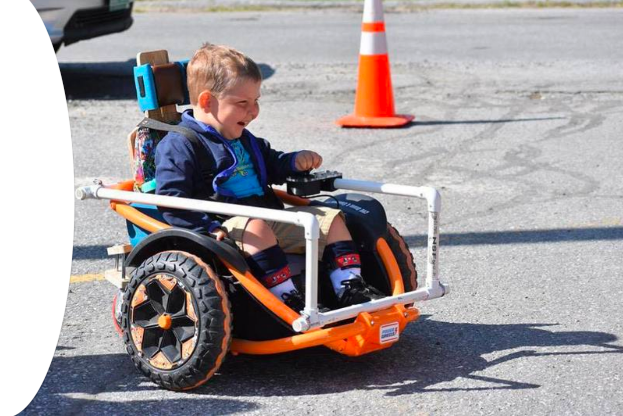 A small boy enjoys a ride in a motorized car