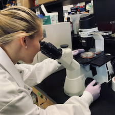 student looking at specimen under microscope