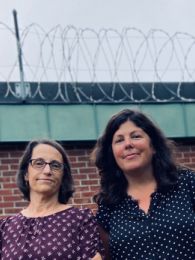 Justice Research team outside a prison with barbed wire fence