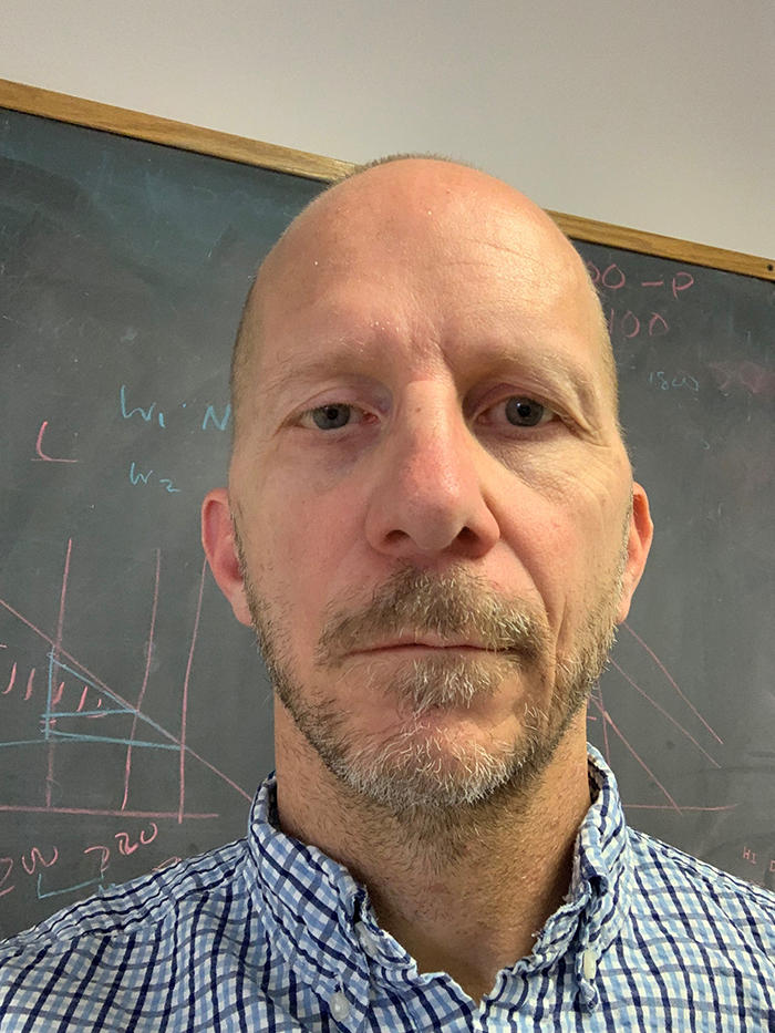 Richard standing in front of a chalkboard