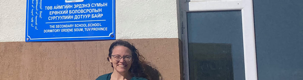 Emily standing in front of a Mongolian dormitory.