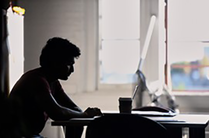 person working at a desk in silhouette