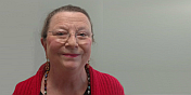 A smiling Gretchen with a gray background