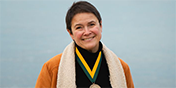 Cristina Mazzoni with her Investiture medal by the shore of Lake Champlain