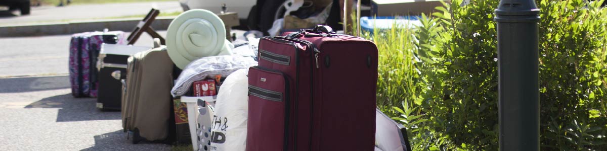 Photo of belongings on sidewalk about to be moved into residence hall. 