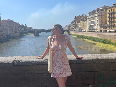 Jenna posing by a bridge on a Roman river.