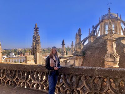 Maddies standing on a striking Spanish bridge with stunning architecture in the background.