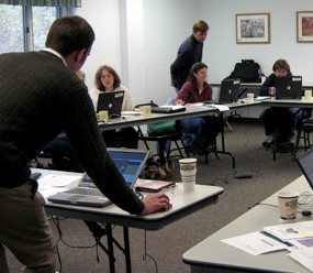 Man with computer teaching a class 