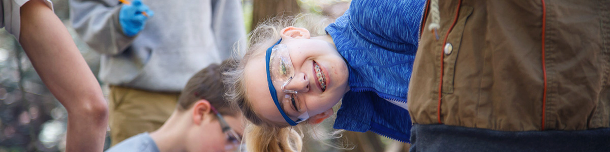 girl smiling and doing outdoor science