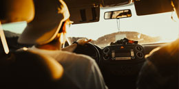 student wearing a baseball cap in the drivers seat driving