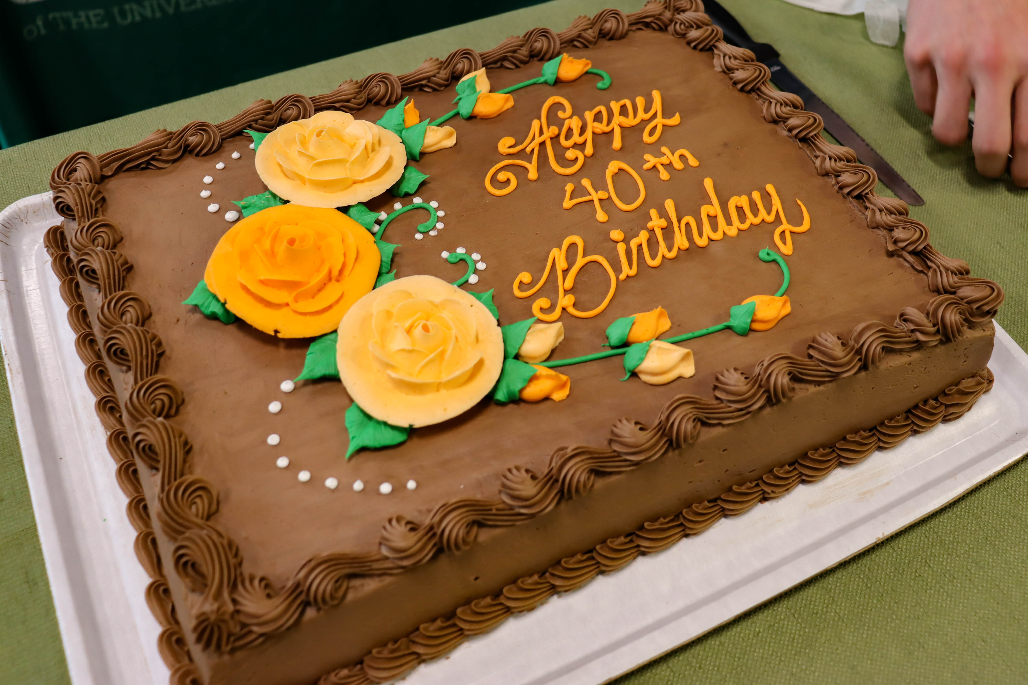 The chocolate cake was decorated with Happy 40th Birthday and flowers in orange.