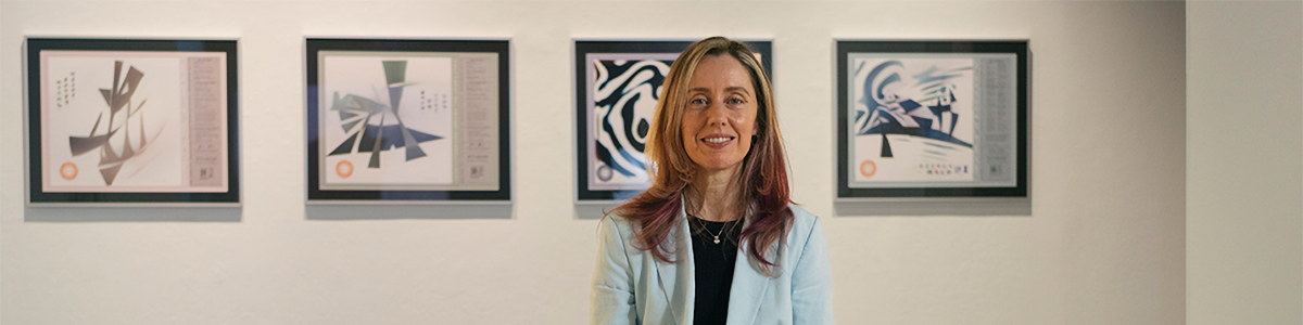 Photo of Jenn Karsen with photos of art created by AI in the background