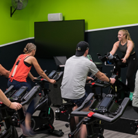 An instructor leads people in a spin class