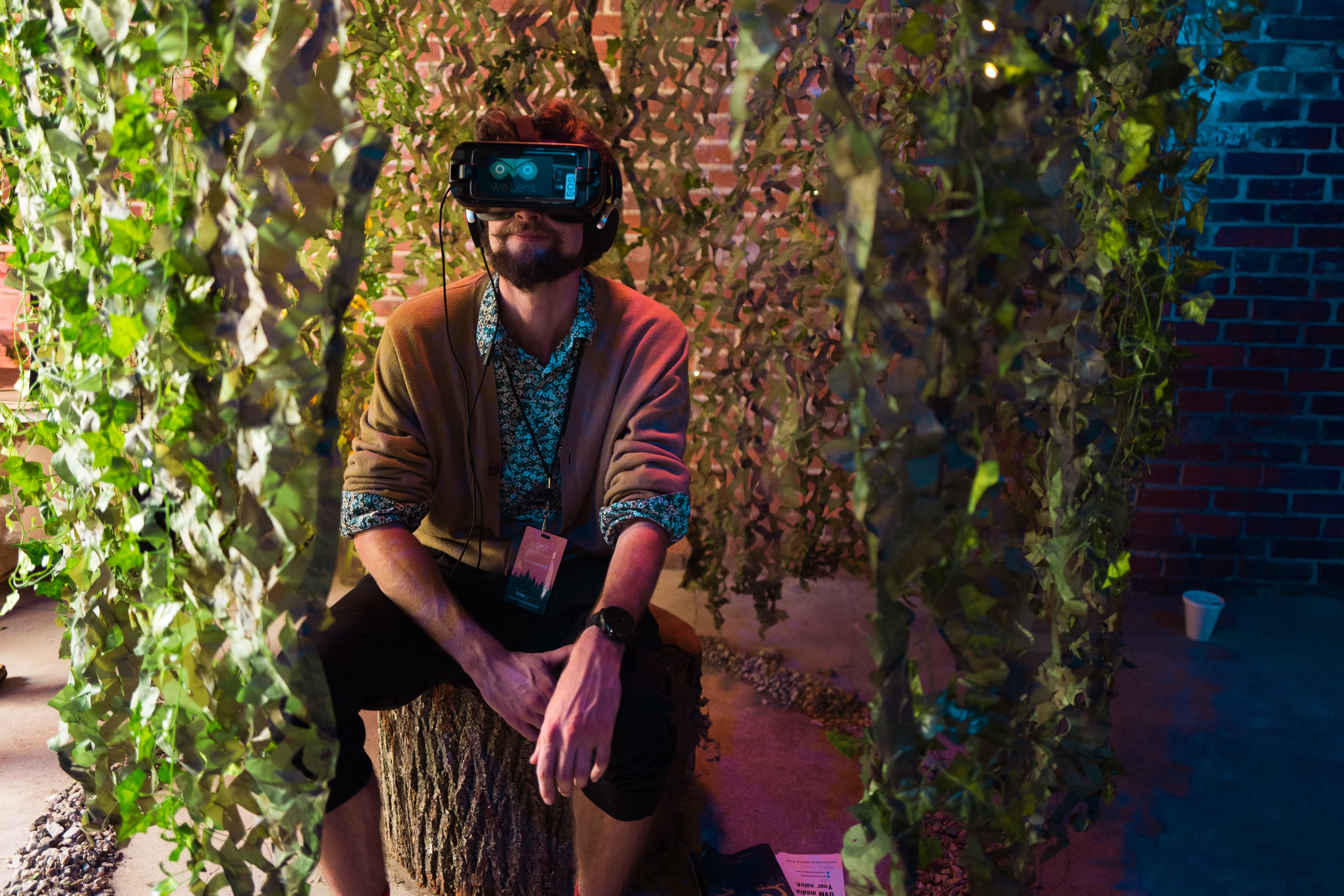 Allen Vance ('19) sitting on a bench wearing virtual reality goggles