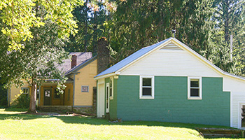 Yellow farmhouse and green cinder block out building