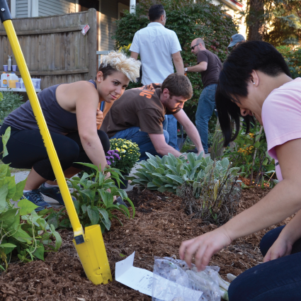 Neighbors working together in a community garden bed on Isham Street