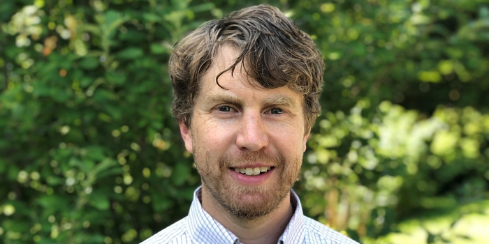 A headshot of Dr. Gregory Rowangould from the shoulders up