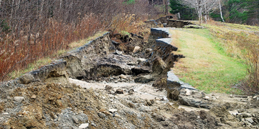 An eroded gravel road following an extreme rain storm