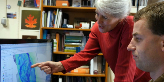 A CEE faculty member and graduate student look at a vizualization of a river