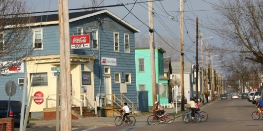 Children ride bikes down a city street.