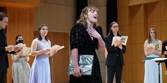 students in song on stage in the Southwick building