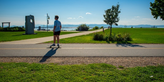 A person skateboards on Burlington's waterfront bike path