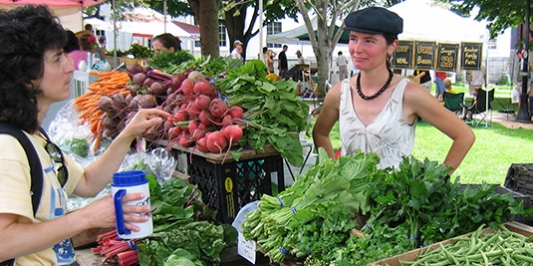 Woman buying radishes at farmer's market