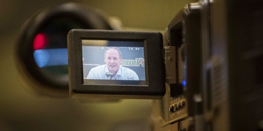 CRVT created videos based on Vermont Research. A shot of the screen on a video camera capturing an interview with a UVM official.